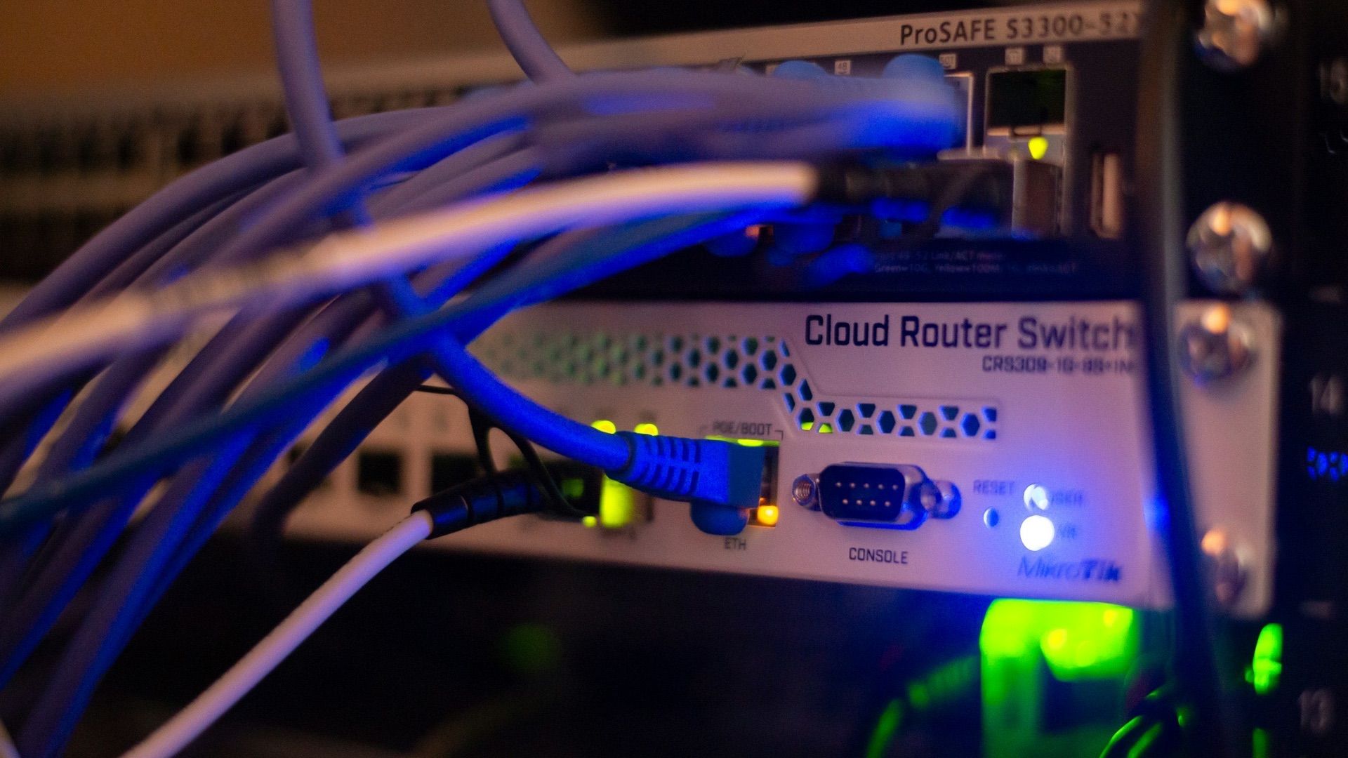 Close-up macro shot of dense network patch cables and connectors in a dark server infrastructure environment
